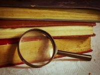 magnifying glass and stack of books