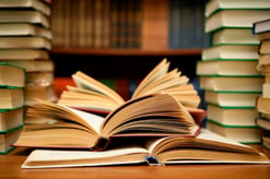 Stack of books on an open desk