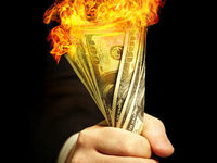 man holding burning cash