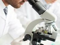 man looking through microscope 