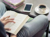 Aerial view of a man reading a book in a coffee shop