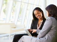 Two business women speaking together 