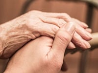 Hand of young person holding the hand of an elderly person