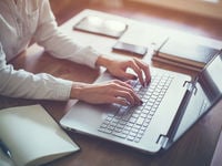 Writing on a laptop. 