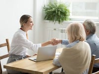 Young professional shaking hands with older couple